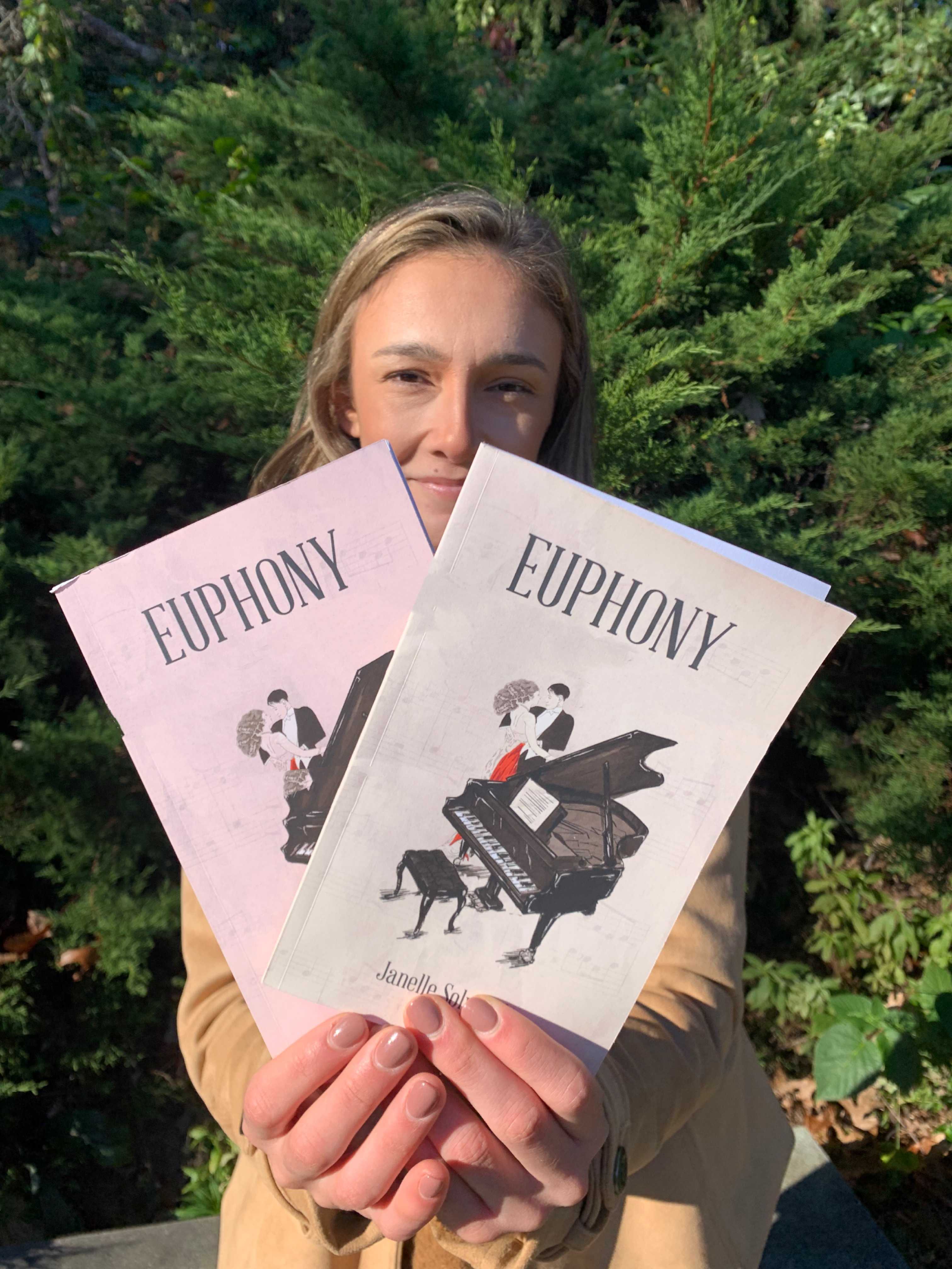 janelle solviletti holding two copies of euphony poetry book